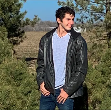 Ethan standing among the pines
