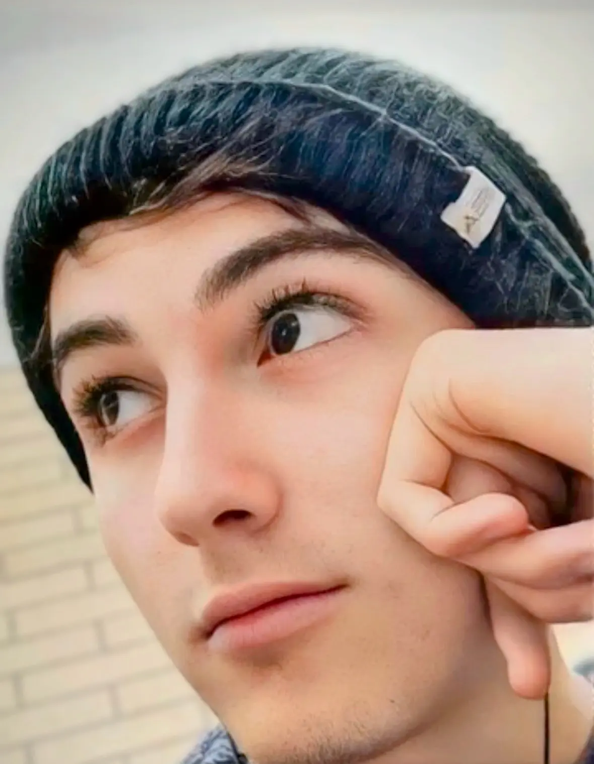 A close portrait of Ethan wearing a beanie
